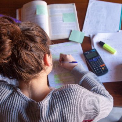 élève à son bureau en cours particuliers qui fait un exercice